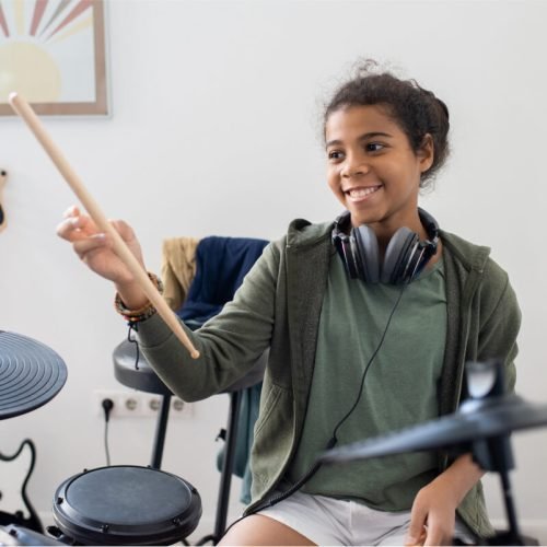 happy-cute-schoolgirl-with-drumsticks-hitting-drum-2021-12-16-00-28-52-utc.jpg