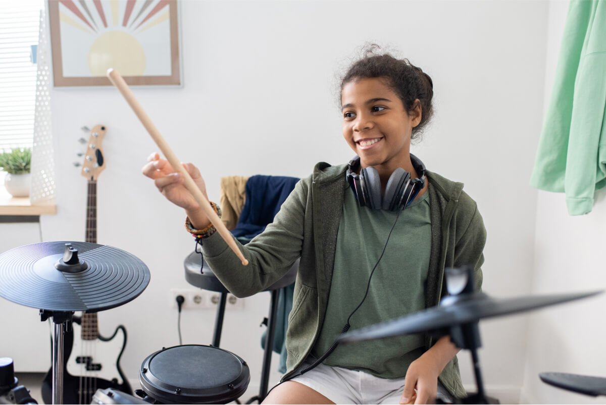 happy-cute-schoolgirl-with-drumsticks-hitting-drum-2021-12-16-00-28-52-utc.jpg